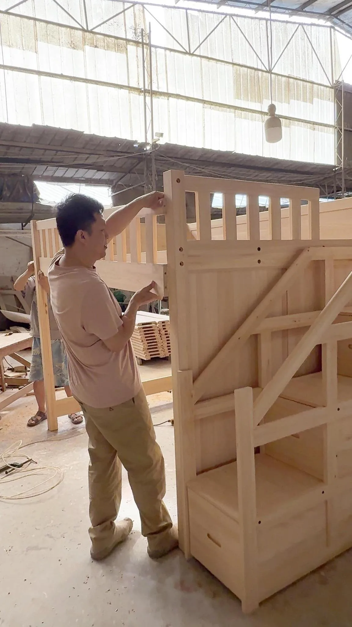 家具大师兄与工人在工厂进行原木家具白胚试装